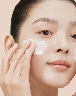 Cleansers Close‑up of an woman applying cleanser to the cheek with fingertips