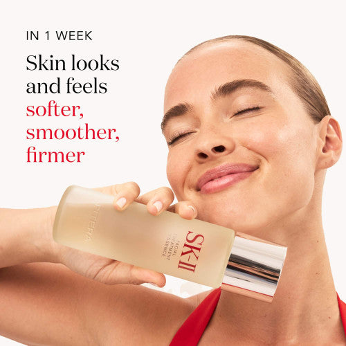 Woman holding an SK-II product with text about skin improvement in one week.