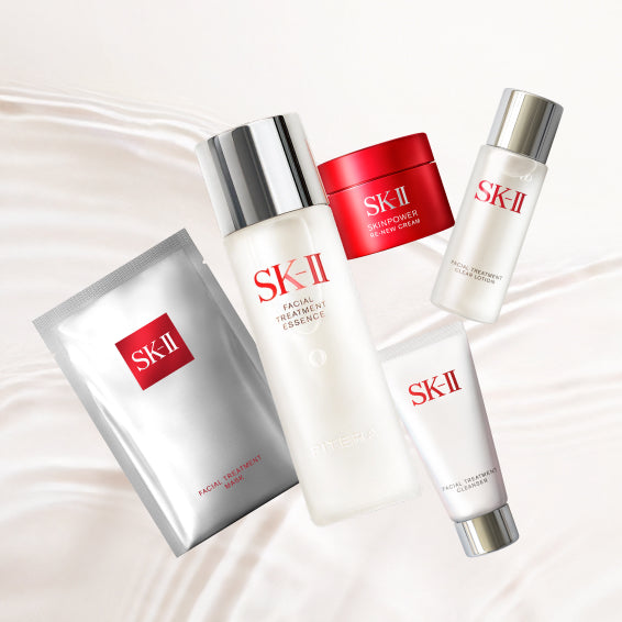 SK‑II bestselling skincare set with essence bottle, cream jar, cleanser tube, and sheet mask arranged on a light background
