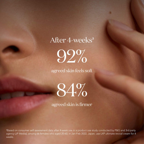 Close-up of SK-II LXP Ultimate Revival Cream applied on cheek with hand touching face on a neutral background