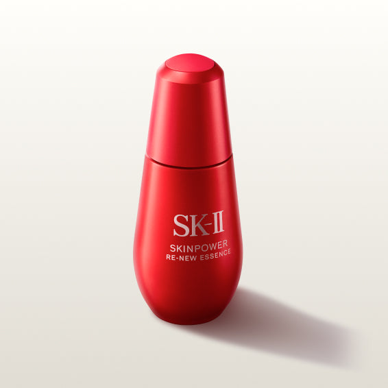 SK-II SKINPOWER Re-New Essence bottle in red packaging placed on a light background with a soft shadow