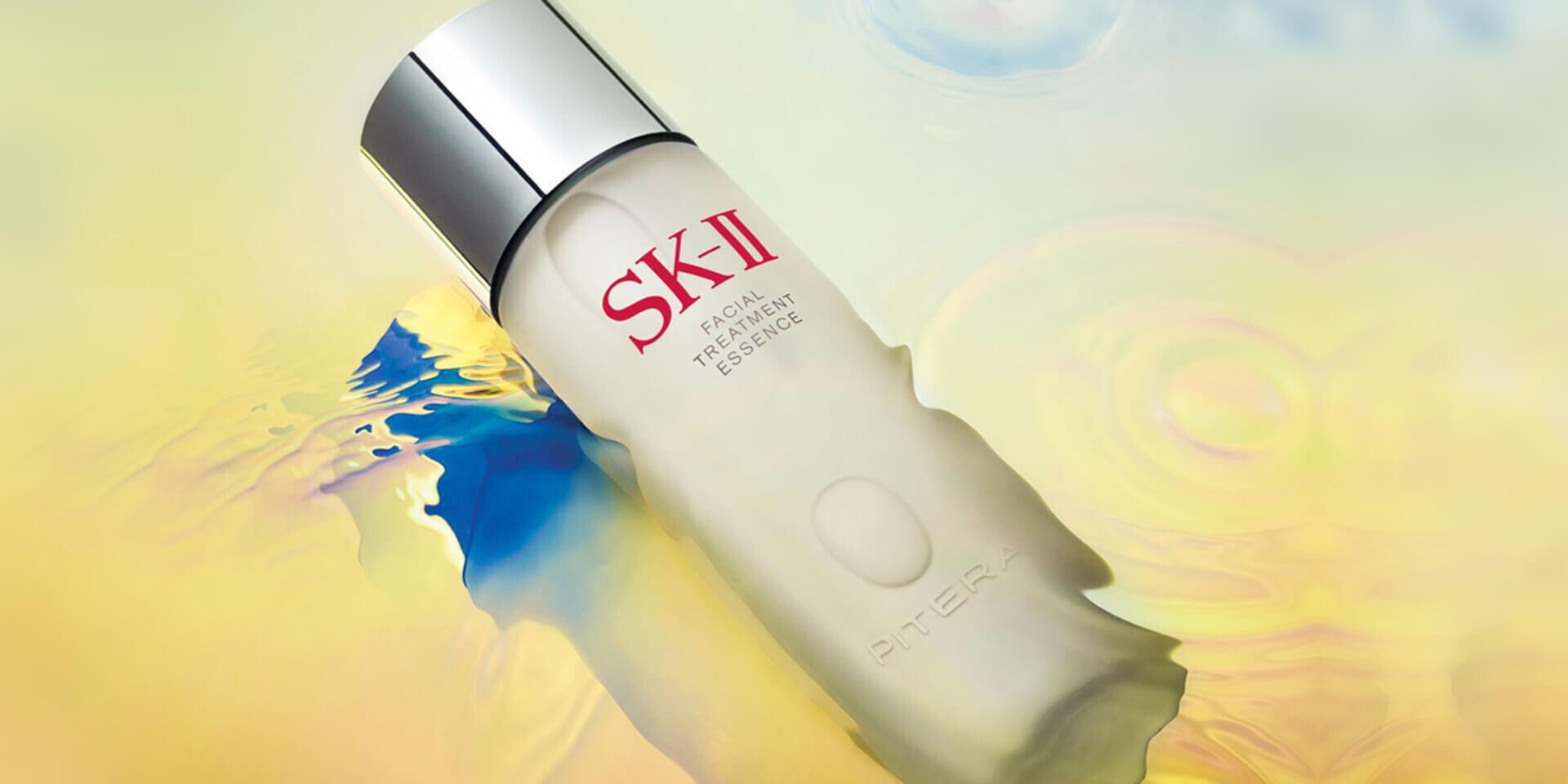 SK-II Facial Treatment Essence bottle with PITERA on a colorful water ripple background