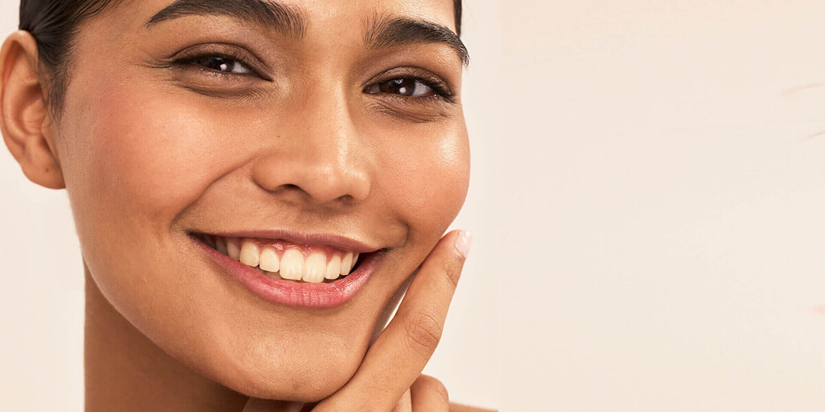 Close-up of lower face with hand touching cheek showing natural skin texture