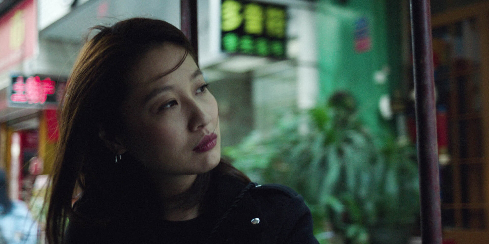 Woman looking to the side in an indoor setting with blurred lights in the background, representing Meet Me Halfway campaign  