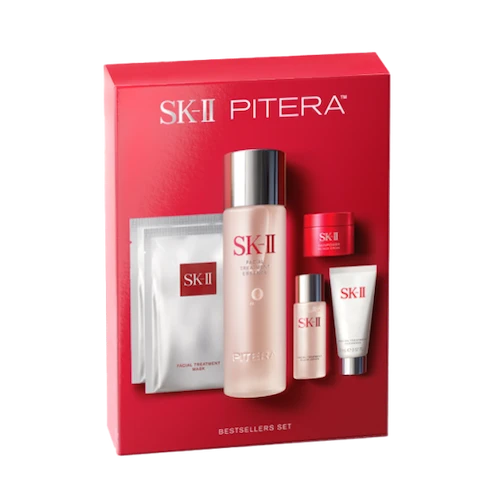 SK‑II bestselling skincare set with essence bottle, cream jar, cleanser tube, and sheet mask arranged on a light background