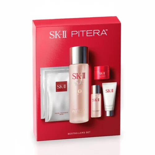 SK‑II PITERA gift set box with facial treatment essence bottle, sheet masks, cream jar, and tube on a plain background