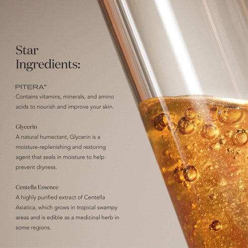 Close-up of SK-II LXP Ultimate Revival Essence in glass container with amber liquid and visible bubbles on a neutral background
