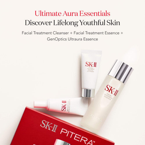 SK-II Pitera Ultimate Aura Essentials Kit items including essence bottle, cleanser tube, and serum tube arranged near a red box on a light background