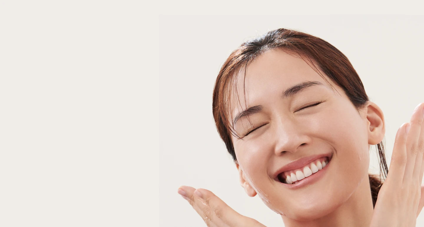 Close-up of a person with eyes closed, head tilted, and hands near face as part of a skincare routine