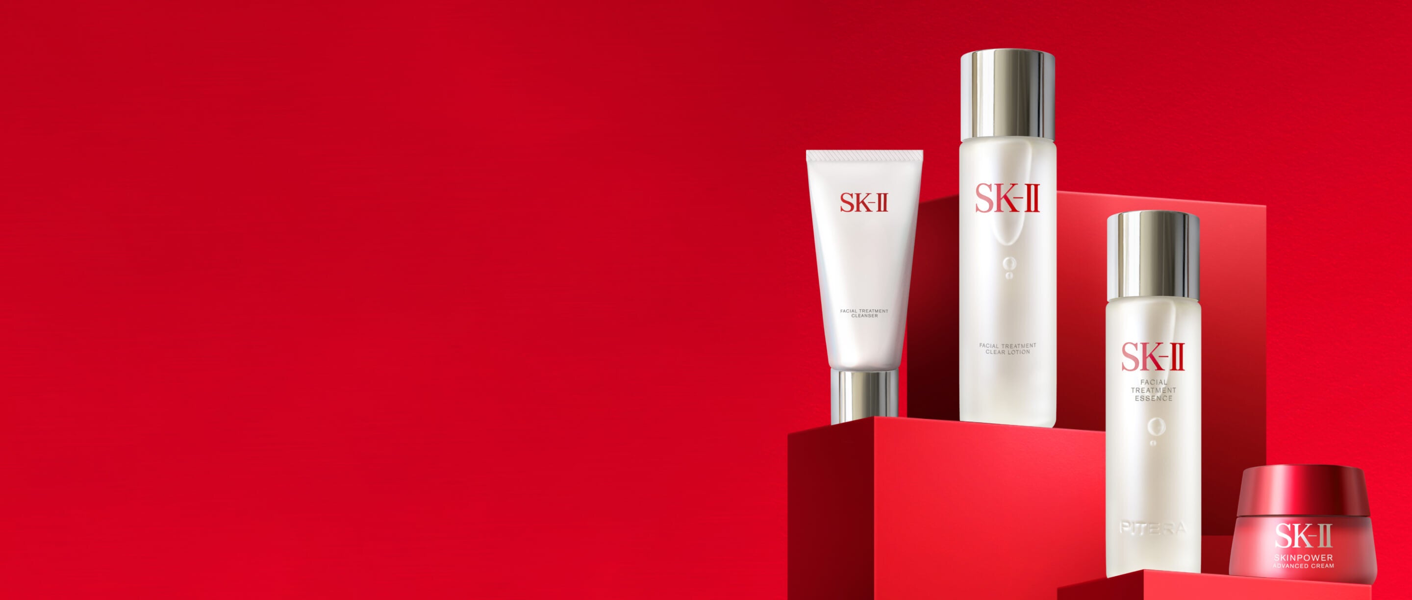 SK‑II skincare products including Facial Treatment Mask, Facial Treatment Essence, and Skinpower Cream arranged on red display blocks
 